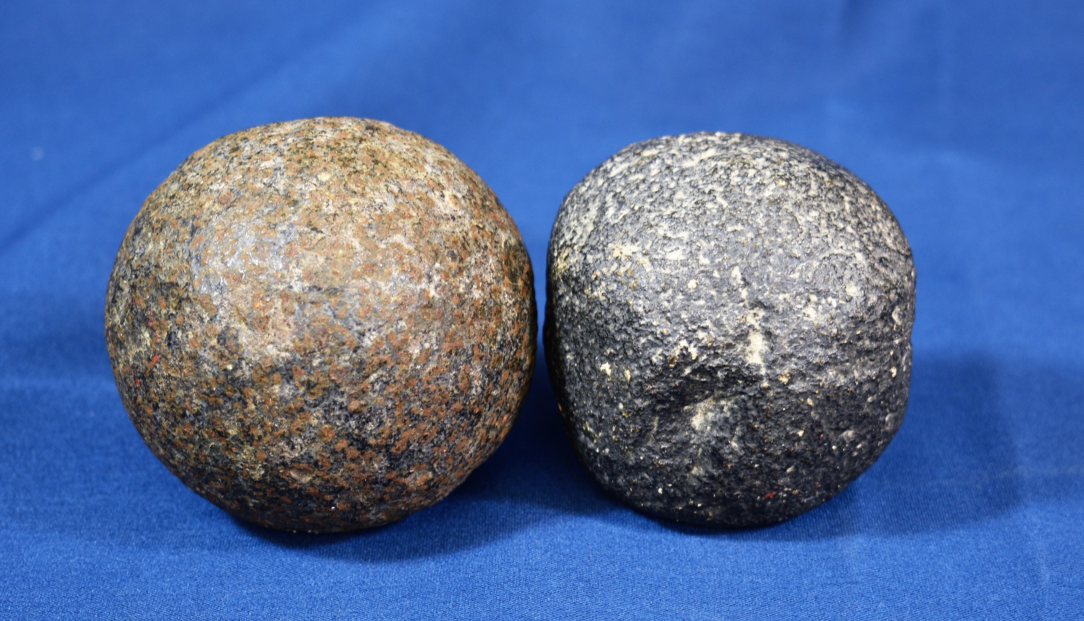 Two cannon balls - round shot - one in stone, the other iron, the largest, 3 1/4in. (8.2cm.).