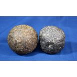 Two cannon balls - round shot - one in stone, the other iron, the largest, 3 1/4in. (8.2cm.).