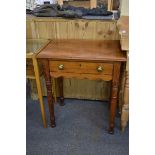 A side table with single drawer and turned legs. Brass handles to drawer. 61cm wide.