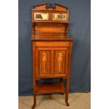 An Edwardian walnut and marquetry music cabinet the mirrored back with single shelf, marquetry panel