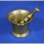 A polished bronze pestle and mortar of typical form, standing 3 3/4in. (9.6cm.) high.