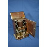 An Art Nouveau oak smokers cabinet inset with a metal plaque fitted with bakelite mixing bowl and