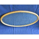 A 19th century giltwood oval wall mirror with bevelled plate and reeded & crossed ribbon frame,