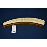 An Inuit Walrus tusk cribbage board the top relief carved with polar bear in trap and walrus head,