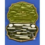 An Edwardian cased manicure set by A. Barrett & Sons, Piccadilly the extensive set with ivory and