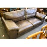 A modern brown leather three seater sofa.