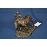 A cold cast bronze resin sculpture of a horse scratching on a cross shaped stone, signed 'Neadon
