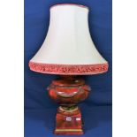 A Thomas Blakemore Limited urn shaped lamp, red and gilt with swag decoration, stitting on square