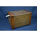 An Art Nouveau style copper and oak coal box the front, sides and lid with copper paneling,