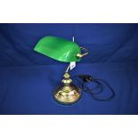 A brass desk lamp with green glass shade.