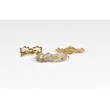 Three Victorian gold and silver brooches comprising a 9ct gold bow brooch with fob attachment; a 9ct