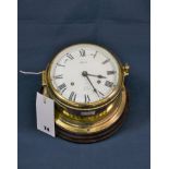A Hermle brass Ships Bell clock in porthole case on circular wooden mount. Condition - Some