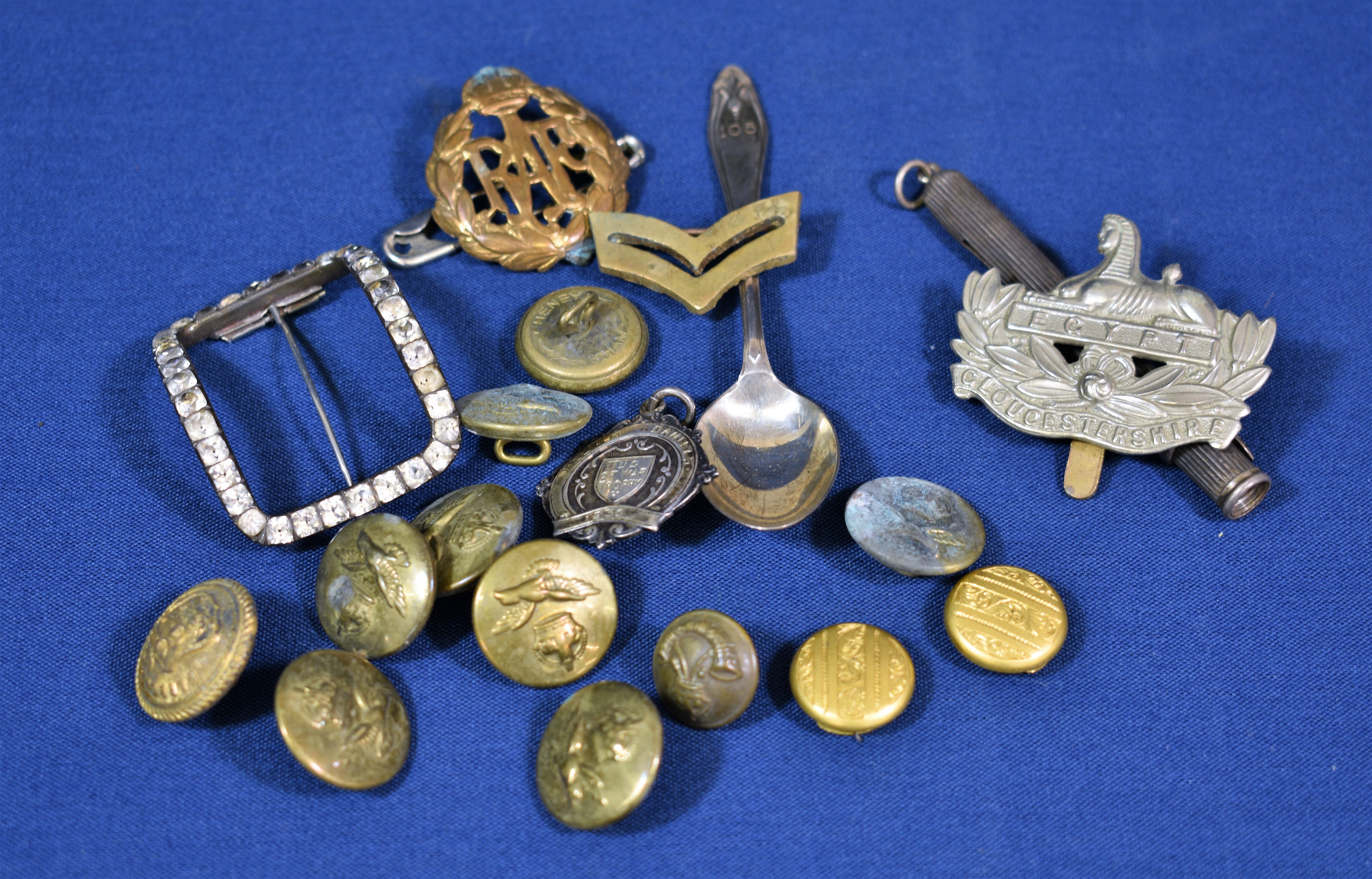 A small collection of military badges, a Georgian silver & paste buckle, silver propelling pencil