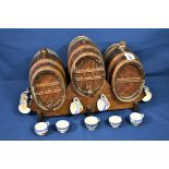 Three barrels on wooden stand with 12 Quimper style liquor cups.