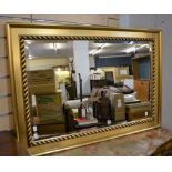 A bevelled glass wall mirror in gilt frame with scroll decoration (54.3cm x 85cm)