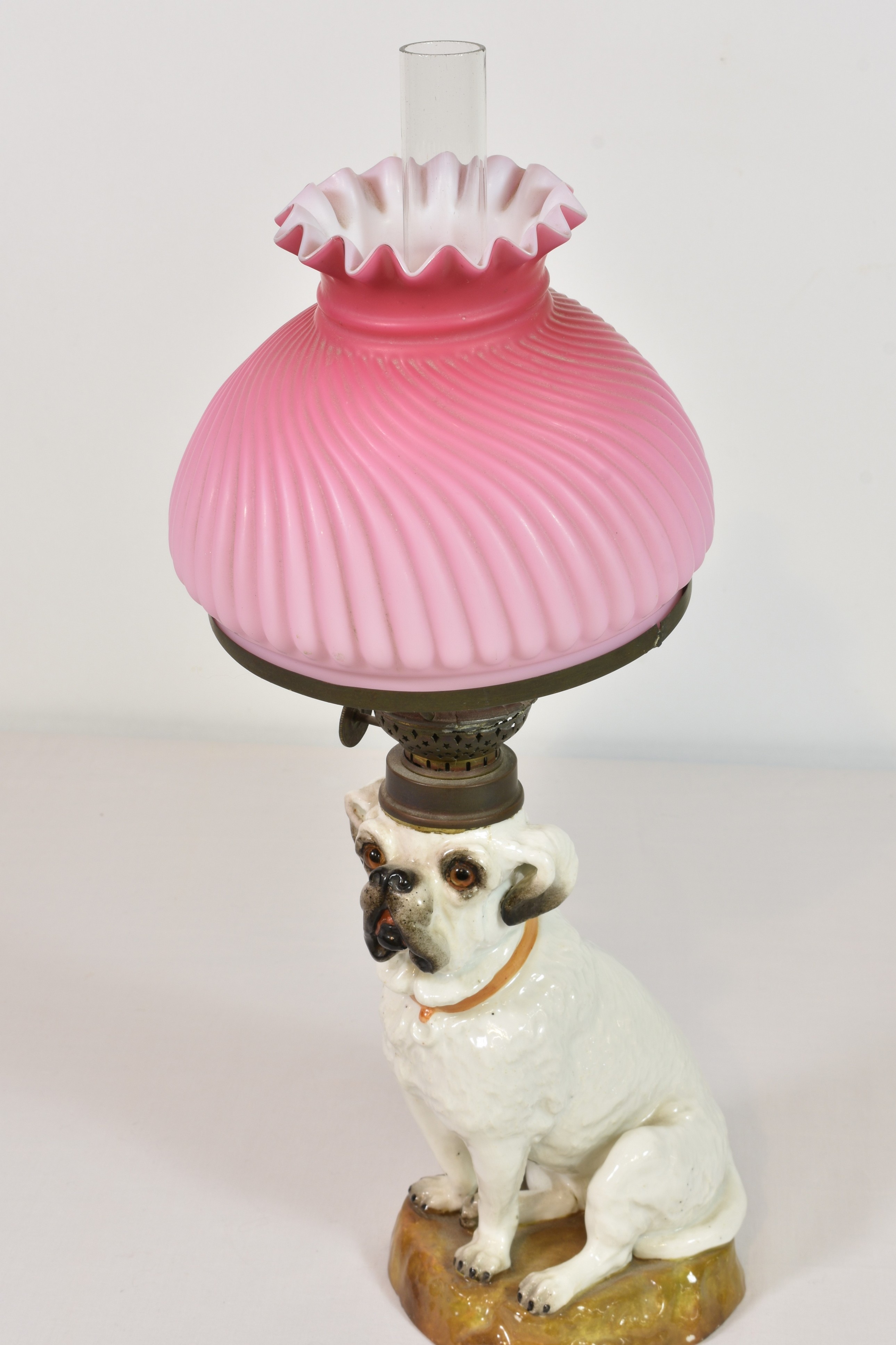 A Staffordshire pottery Bull Terrier dog converted to oil lamp pink milk glass shade (restored)