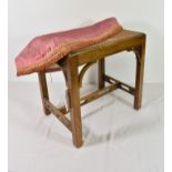 An early 20th century stained beechwood stool in the Chippendale Gothic style with caned seat.
