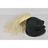 An Eda Millinery black cloche style hat and a cream Philip Somerville Harrods pillbox hat with