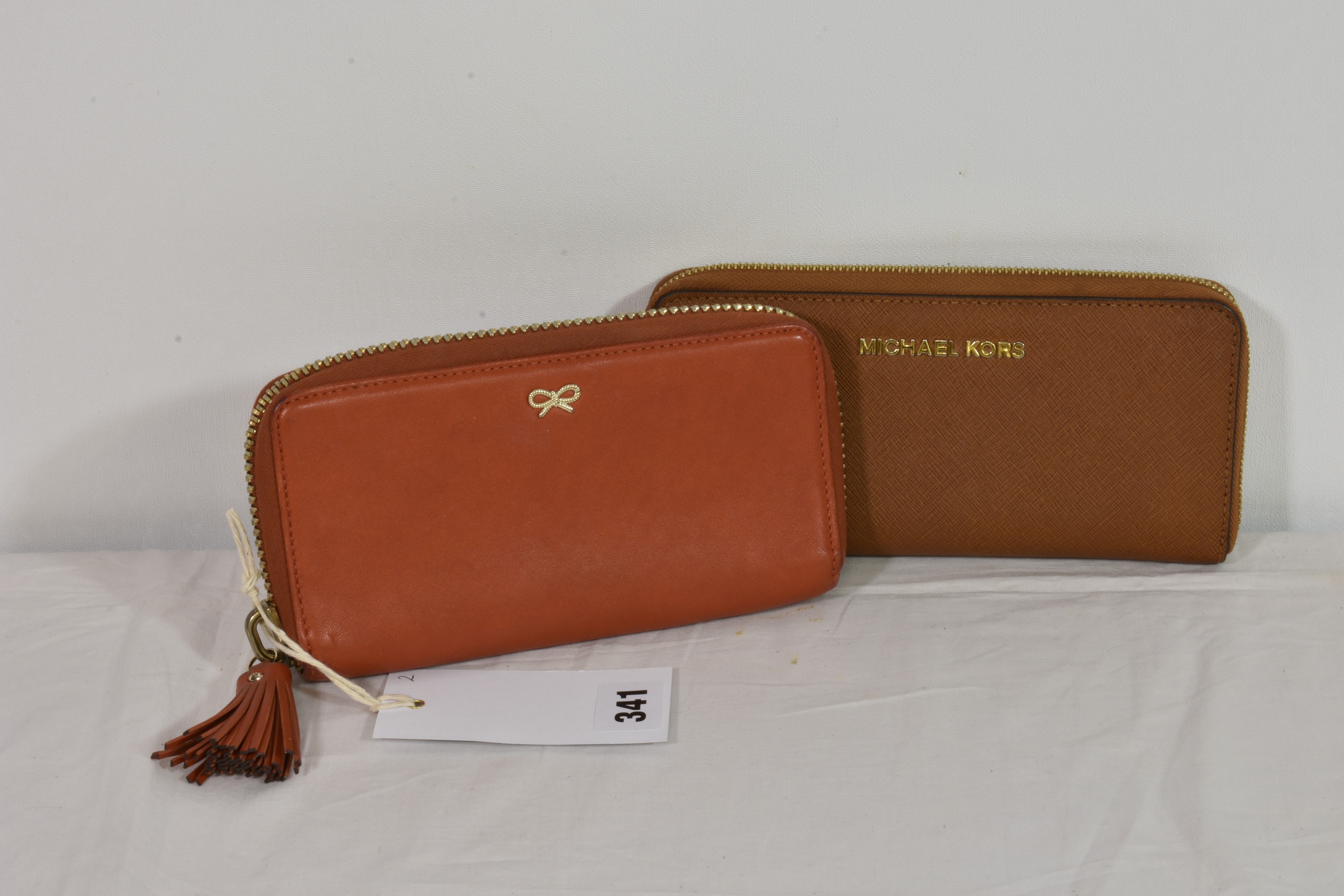 An Anya Hindmarch burnt orange leather purse with tassel zip together with a tan Michael Kors