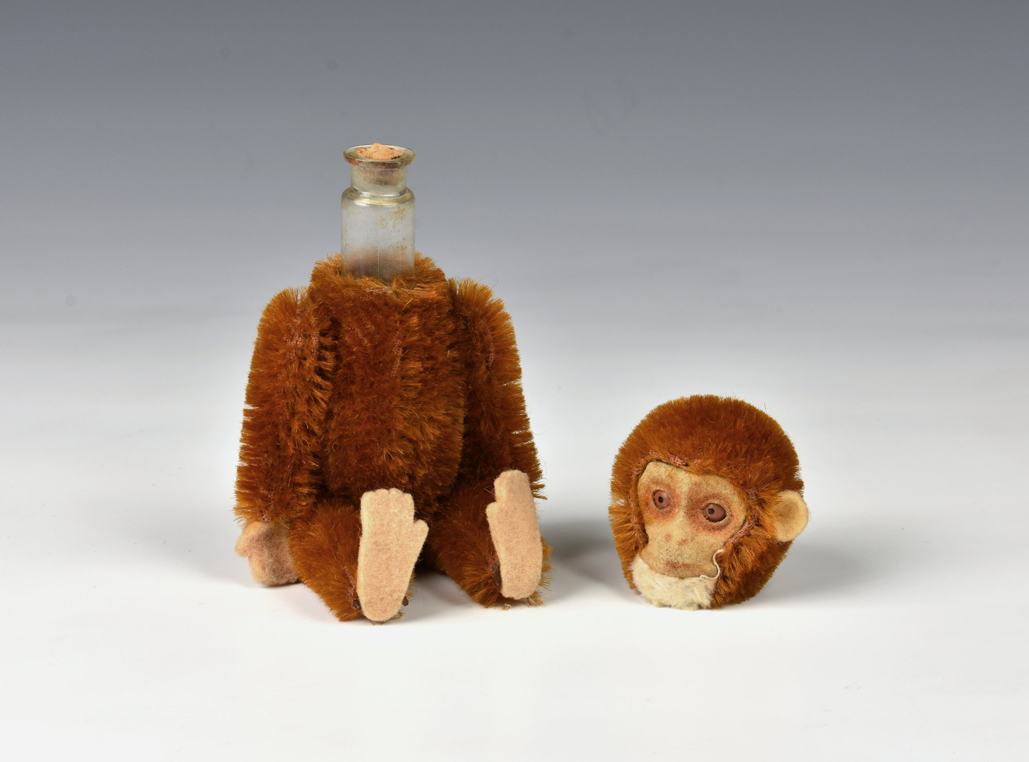 A novelty Schuco perfume monkey, c.1920's, in cinnamon plush, felt hands, feet and ear's,