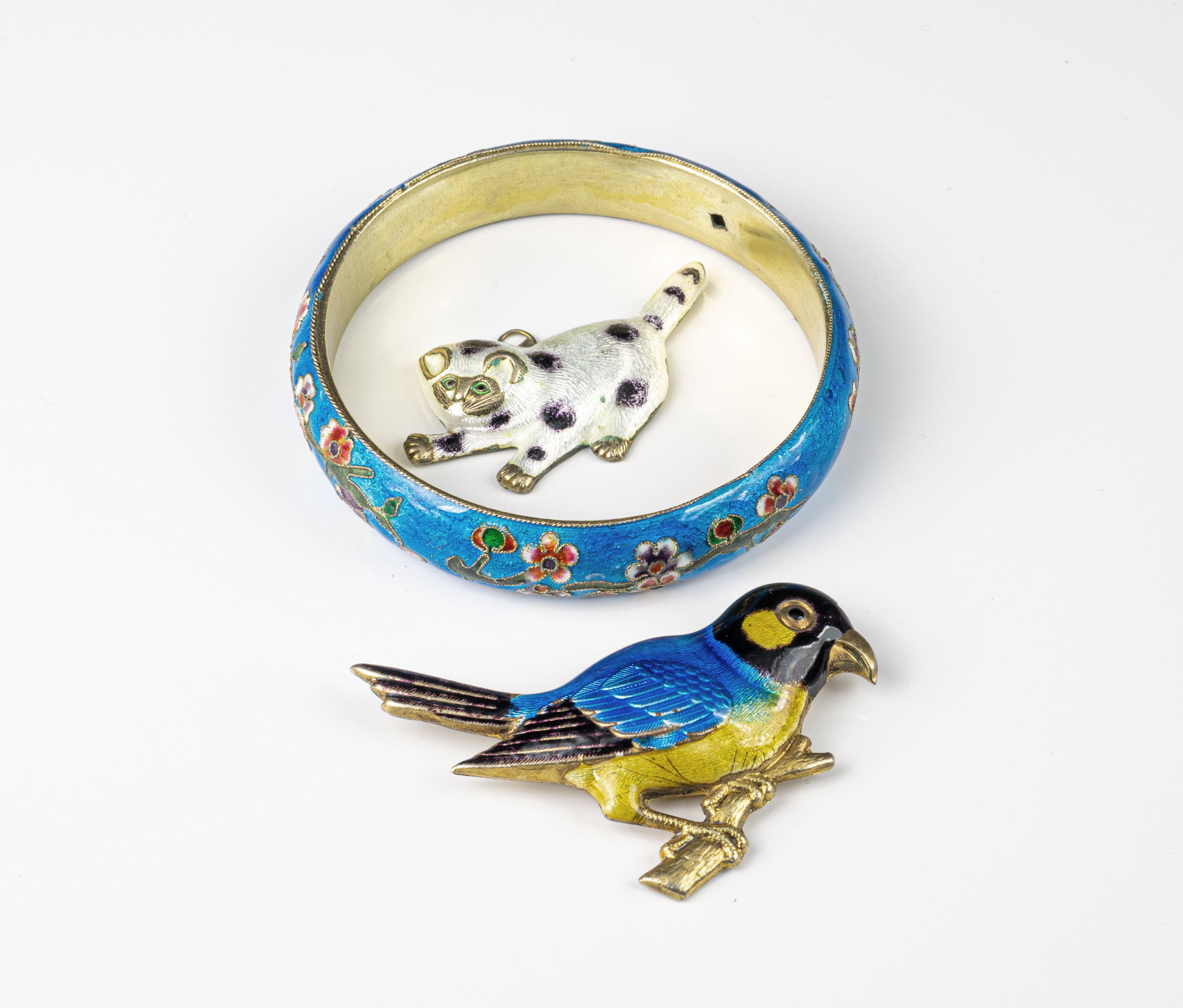 A Chinese enamelled silver-gilt bangle, unmarked, decorated with a floral spray on blue ground,
