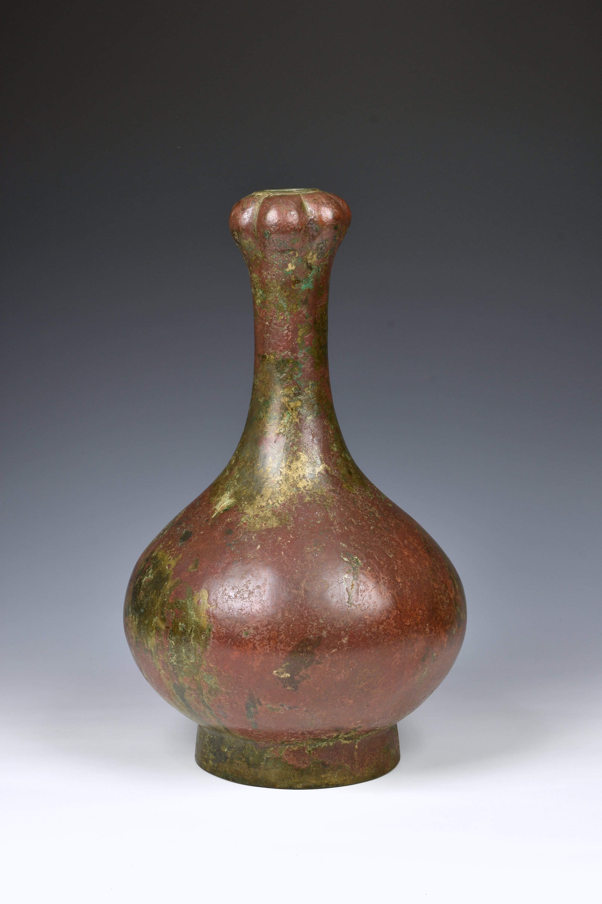 A Chinese bronze garlic head bottle vase, probably Han Dynasty (206BC-220AD), the compressed