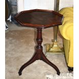 A mid-19th century octagonal mahogany tilt-top tripod table the tray top on a turned baluster