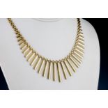 A 9ct yellow gold fringe necklet 16in. (40.5cm.) long.