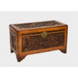 A Chinese carved camphorwood chest early 20th century, the front and top carved in high relief
