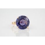 A 9ct rose gold and faux-Alexandrite ring the round cut 13mm. faux-Alexandrite in a pierced basket