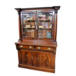 A Victorian mahogany, rosewood, ebonised and brass inlaid cupboard bookcase the flared and stepped