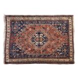 A Shiraz rug first half 20th century, the single dark blue medallion on a madder field with all over