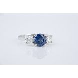 An 18ct white gold, sapphire and diamond three stone ring the central 2.42ct round cut sapphire