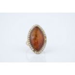 A Victorian amber and seed pearl ring the marquise shaped amber within a border of seed pearls, size