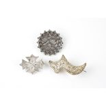 Three antique silver brooches one circular with scalloped and beaded edge, chased with roses,