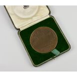A cased bronze Commemorative Medallion from troop transport SS Queen Mary the obverse reading