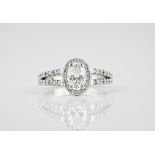 A platinum and diamond cluster ring the central oval cut 1.07ct diamond, GIA cert. G/VS1, within a