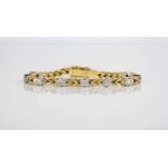 An 18ct two colour gold and diamond bracelet the fancy link bracelet with nine brilliant cut