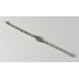 An 18ct white gold and diamond bracelet with polished and matted chevron pattern, centred by a twist