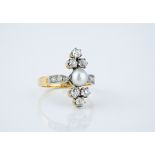 An antique 18ct gold, pearl and diamond ring the central pearl with trios of old cut diamonds