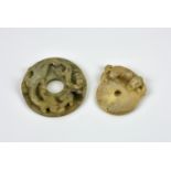 Two Chinese carved jade Pi discs probably 19th century, the larger in shaded green jade, having