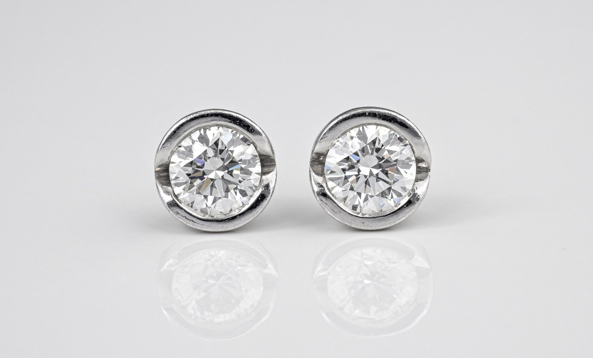 A fine pair of 18ct white gold and diamond solitaire stud earrings by Andrew Geoghegan the brilliant