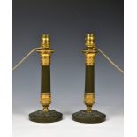 A pair of French patinated bronze and ormolu candlesticks 19th century, the tapered fluted columns