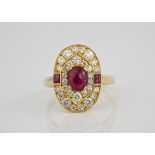 An 18ct gold, ruby and diamond Art Deco style cluster ring the central cabochon ruby within a two-