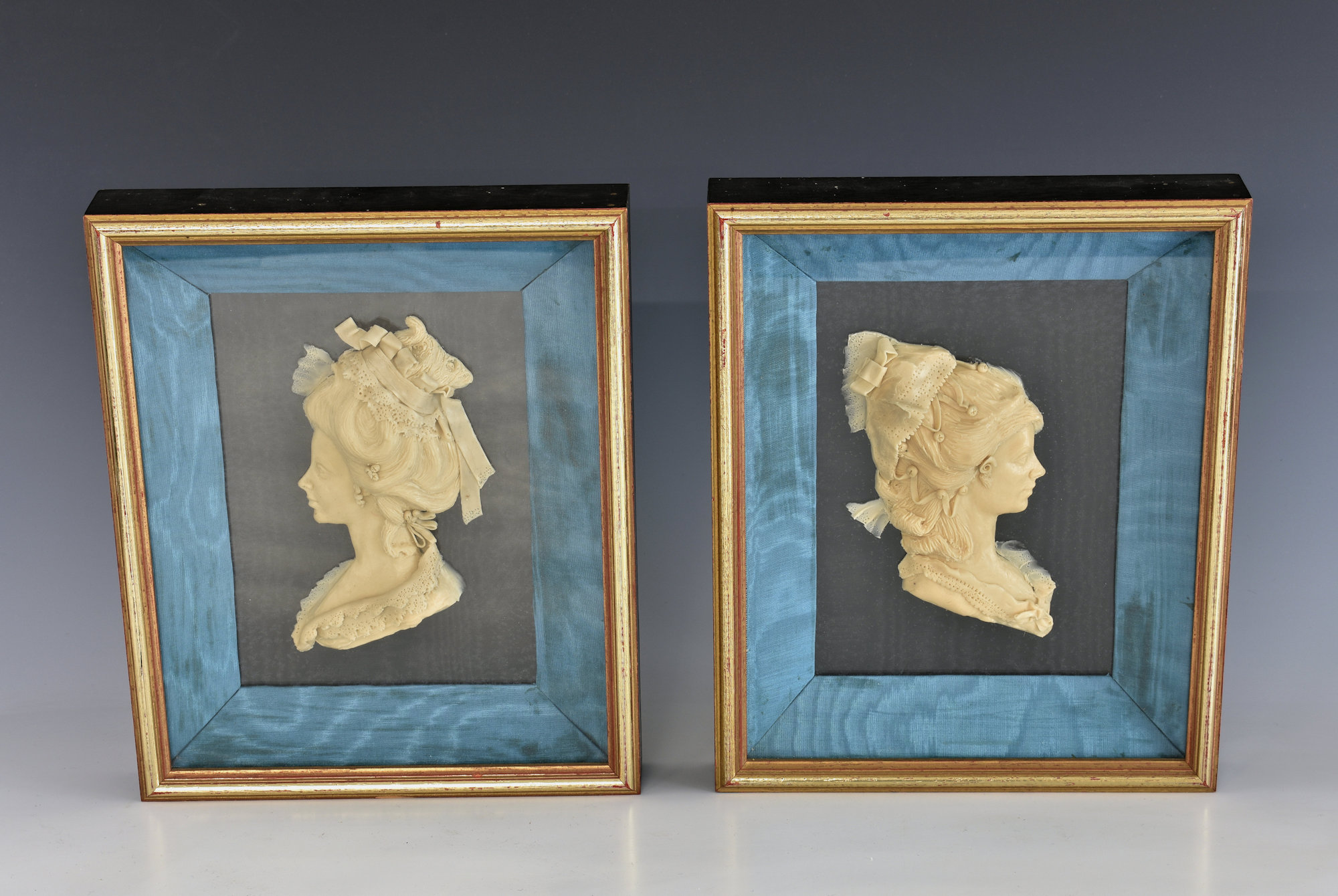 A pair of French cased, carved wax silhouette busts of ladies in 18th century dress and