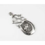 A silver horse riding pendant early 20th century, in the form of a rearing horse inside a horseshoe,