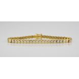 An 18ct yellow gold and diamond line bracelet the brilliant cut diamonds in rubover settings,