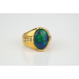 An 18ct yellow gold, black opal and diamond ring the oval opal over broad, tapering shoulders,