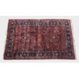 A Persian rug third quarter 20th century, the madder field with all over decoration of flowers and