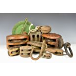 A collection of antique ship's wooden blocks and pulleys of varying sizes, together with a metal